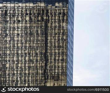 building reflected on glass windows of office skyscraper ; abstract background