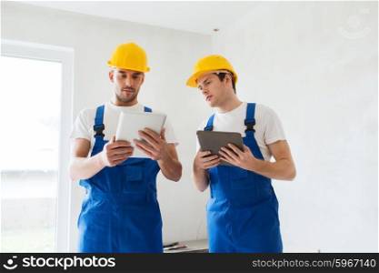 building, renovation, technology, electricity and people concept - two builders with tablet pc computers indoors