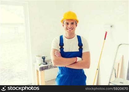 building, repair and people concept - smiling young builder in hardhat with working tools indoors