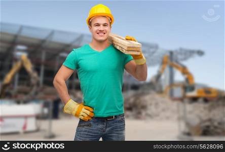 building, repair, construction and maintenance concept - smiling male manual worker in protective helmet carrying wooden boards