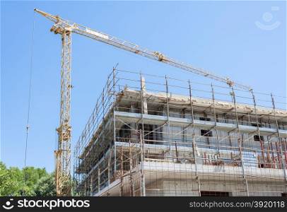 Building under construction with crane and scaffolding