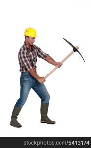 Building worker using a pickaxe, studio shot