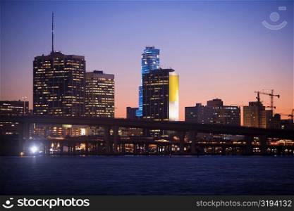 Buildings at the waterfront lit up at dusk, Miami, Florida, USA