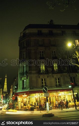 Buildings in front of a tower lit up at night, Eiffel Tower, Paris, France