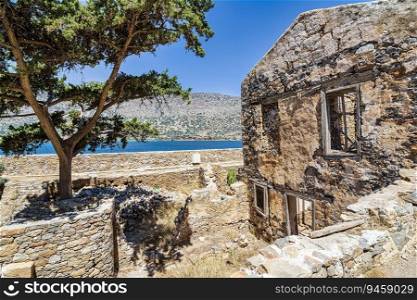 Buildings in the fortress on the island of Spinalonga at the Gulf of Elounda, Crete, Greece. Sea background. Here were isolated lepers, humans with Hansen&rsquo;s disease.. Buildings in the fortress on the island of Spinalonga at the Gulf of Elounda, Crete, Greece. Sea background.