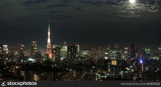 Buildings lit up at night in a city with Tokyo Tower in the background, Tokyo, Japan