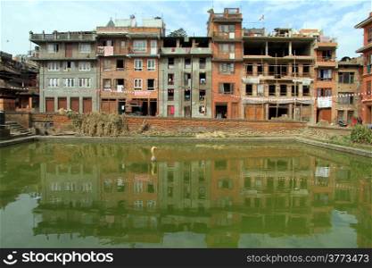 Buildings near pond with green water in Bhaktapur, Nepal