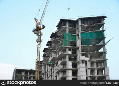 buildings under construction and cranes under a blue sky