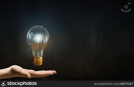 Bulb in hand. Businessman presenting glass glowing light bulb in his hand