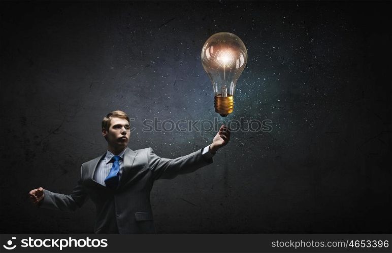 Bulb in hand. Businessman reaching hand to touch glass light bulb