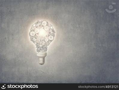 Bulb of gears. Light bulb concept with gears inside on cement background