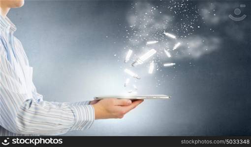 Bulb on tablet screen. Human hands holding tablet pc with light bulb on it
