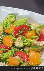 Bulgarian salad from pepper, cucumbers, tomato, green onion with sesame and oil