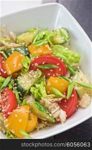 Bulgarian salad from pepper, cucumbers, tomato, green onion with sesame and oil