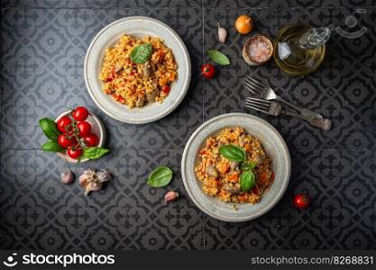 bulgur with chicken hearts and vegetables. Delicious healthy dish on dark background, top view. Bulgur pilaf. Bulgur with chicken hearts
