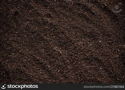 Bulk earthworm fertilizer for planting, soil texture background.