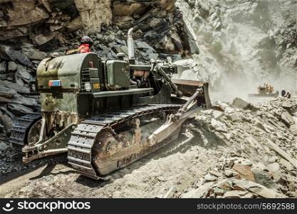 Bulldozer doing mountain road construction in Himalayas. Himachal Pradesh, India