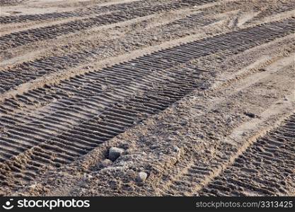 bulldozer tracks on disturbed dirt in a construction place