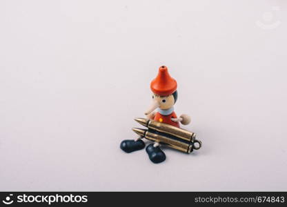 Bullet and wooden pinocchio doll with his long nose
