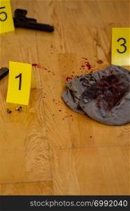 Bullets and gun next to markers at crime scene