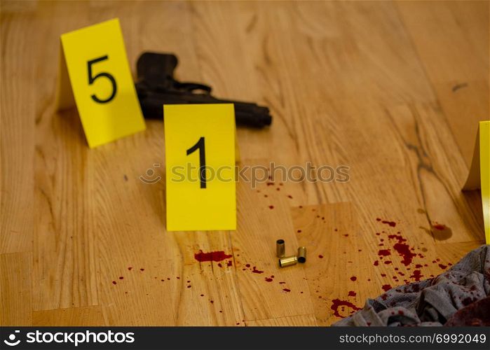 Bullets and gun next to markers at crime scene
