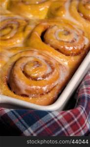 bun of pumpkin with cinnamon in the form of snails in a creamy glaze ceramic roasting pan