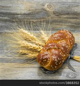 Bun with sesame seeds and ears on wooden background.