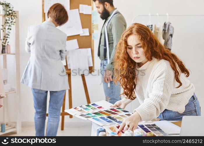 bunch fashion designer working atelier with color palette