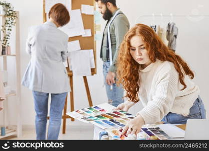 bunch fashion designer working atelier with color palette