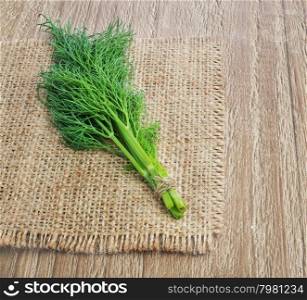 bunch fresh dill tied with twine on wooden background