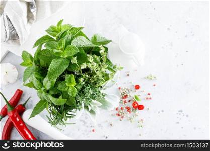 Bunch of aromatic herbs in mortar on kitchen table