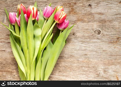 Bunch of beautiful tulip flowers on wooden background with copy-space