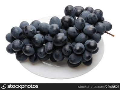 Bunch of black grapes on a white plate, isolated