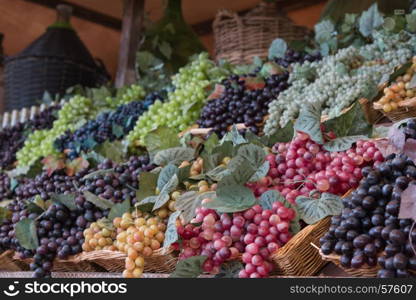 Bunch of Colorful Grapes in Wicker Basket on Wooden Shelf For Sale