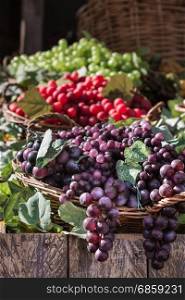Bunch of Colorful Grapes in Wicker Basket on Wooden Shelf For Sale
