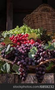 Bunch of Colorful Grapes in Wicker Basket on Wooden Shelf For Sale