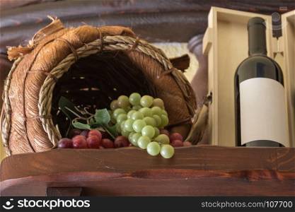 Bunch of Colorful Grapes in Wodden Basket and Wine Bottle with its Box on Shelf. Bunch of Colorful Grapes in Wodden Basket and Wine Bottle with i