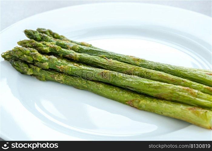 Bunch of cooked asparagus on the white plate