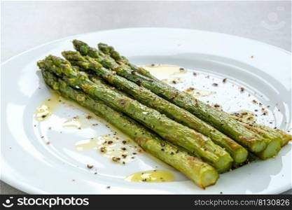 Bunch of cooked asparagus on the white plate