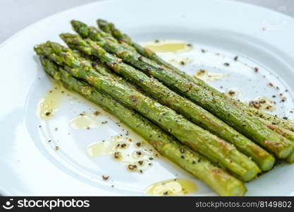 Bunch of cooked asparagus on the white plate