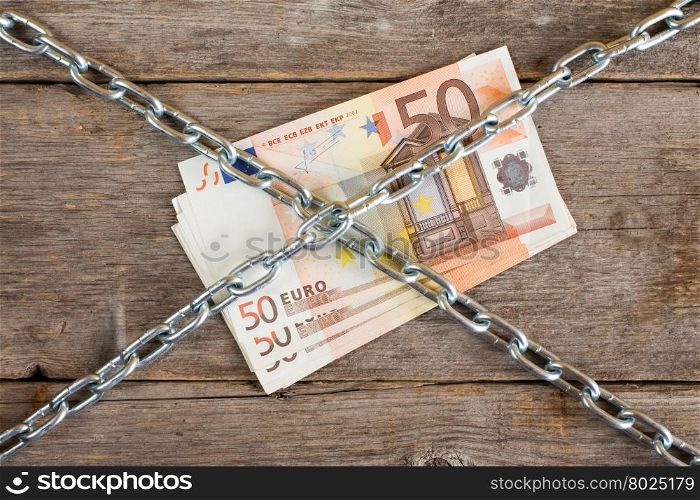 Bunch of fifty euros with chain , concept money tied up