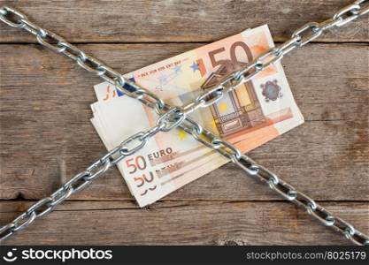 Bunch of fifty euros with chain , concept money tied up
