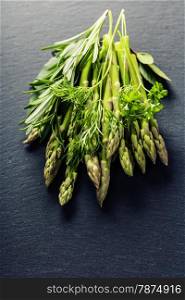 Bunch of fresh asparagus on slate background