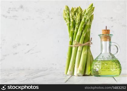 Bunch of fresh asparagus with bottle of olive oil