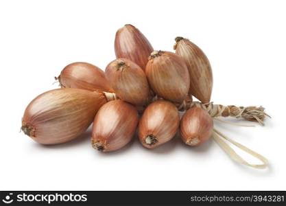 Bunch of fresh brown french shallots on white background