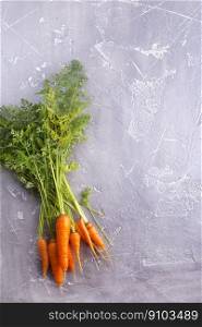 Bunch of fresh carrots with green leaves over wooden background. Vegetable.. Bunch of fresh carrots with green leaves over wooden background.