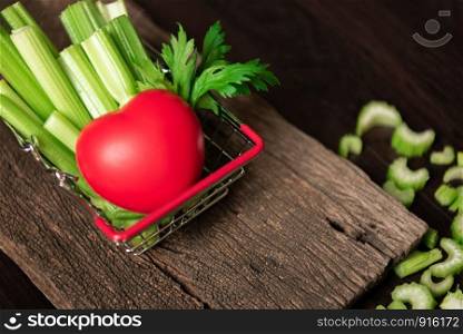 Bunch of fresh celery stalk in shopping basket with leaves and red heart for healthy concept. Food and ingredients of vegetable. Freshness herbal and low calories for dieting with plenty of vitamin