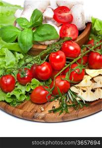 Bunch of fresh cherry tomato with basil, pasta and mushrooms, on white background