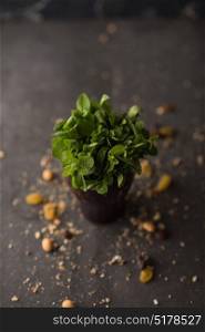 Bunch of fresh mint in cup on rustic stone background