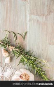 Bunch of fresh of garden rosemary on wooden table, rustic style, fresh organic herbs with salt and garlic. Top view with copy space